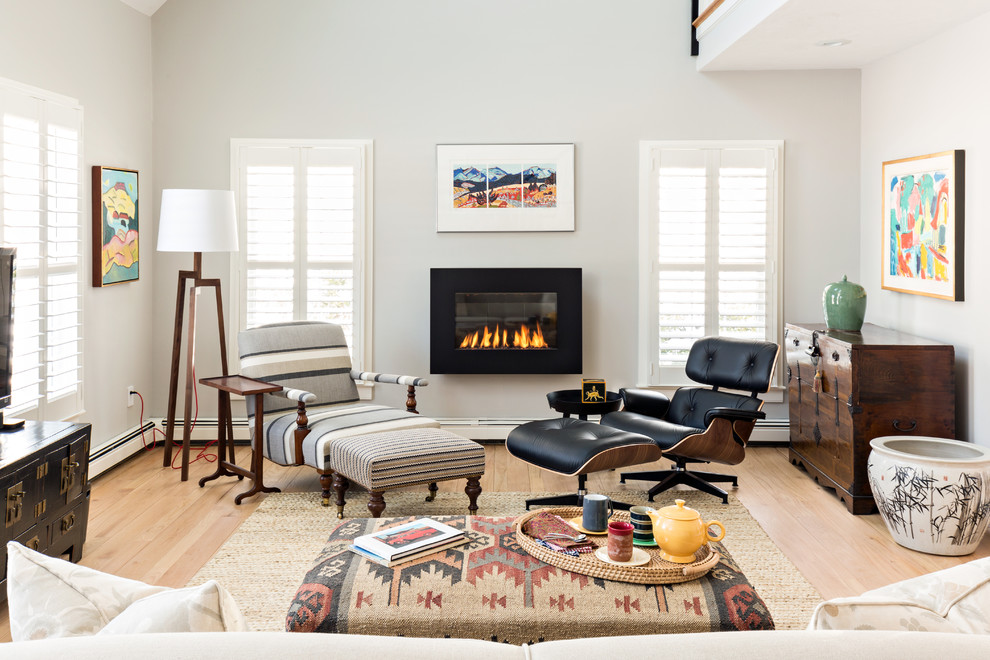 Transitional living room in Boston with grey walls, light hardwood floors and a ribbon fireplace.