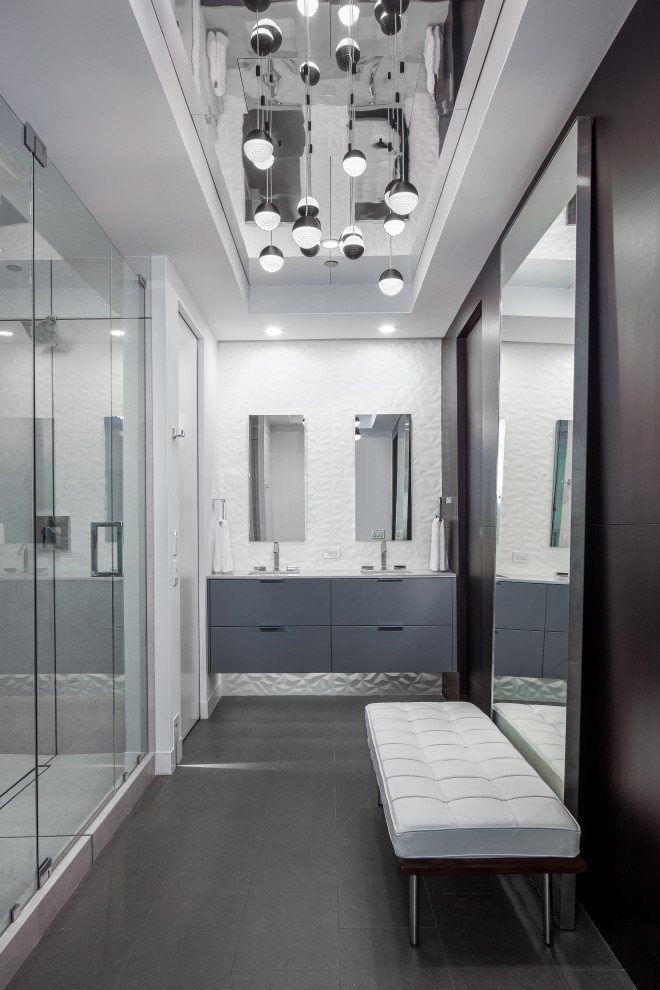 This is an example of a mid-sized modern master bathroom in Miami with flat-panel cabinets, grey cabinets, a two-piece toilet, gray tile, porcelain tile, white walls, porcelain floors, an undermount sink, engineered quartz benchtops, grey floor, a hinged shower door, white benchtops, a niche, a double vanity, a floating vanity, coffered and wood walls.
