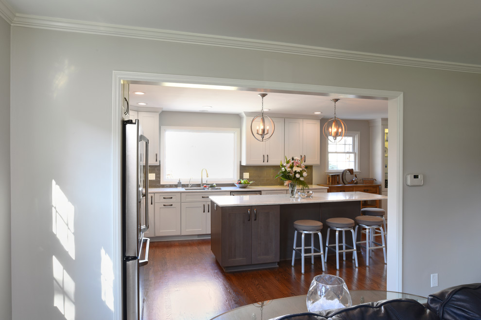 Transitional l-shaped medium tone wood floor eat-in kitchen photo in Orange County with a double-bowl sink, shaker cabinets, white cabinets, marble countertops, gray backsplash, glass tile backsplash, stainless steel appliances and an island