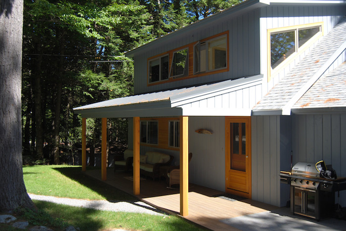 Mid-sized country two-storey blue exterior in Portland Maine with wood siding and a clipped gable roof.