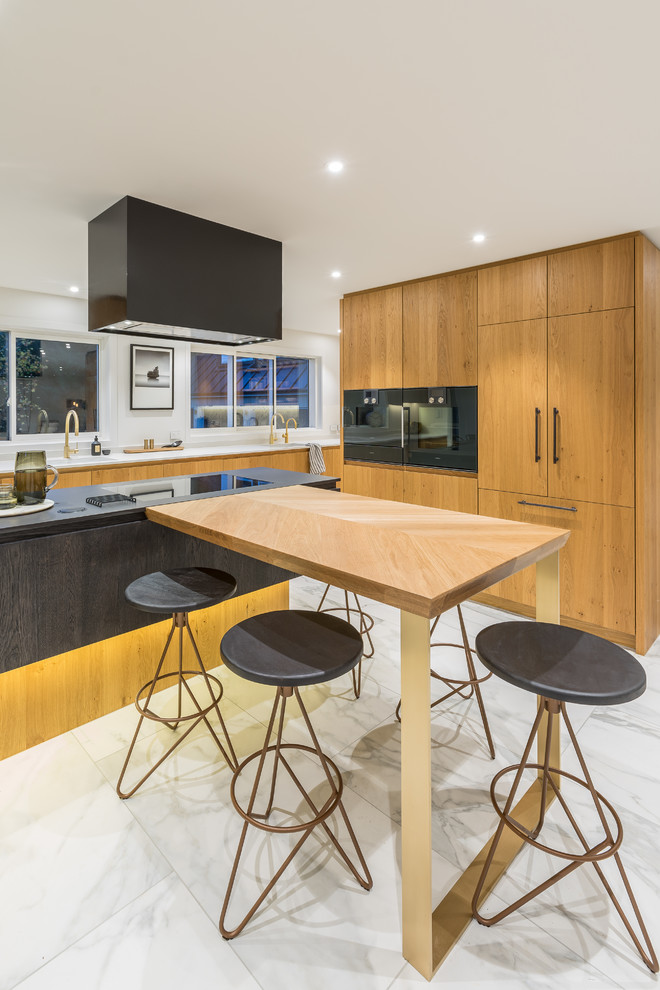 Large contemporary L-shaped kitchen pantry in Auckland With an Undermount Sink, Flat-panel Cabinets, Light Wood Cabinets, Quartz Benchtops, White Splashback, Stone Tile Splashback, Black Appliances, Porcelain Floors, multiple Islands and White Floor.