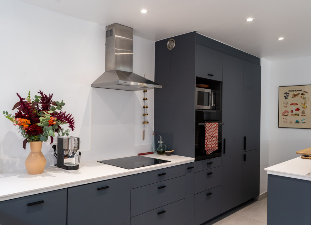 Large contemporary grey and white l-shaped open plan kitchen in Paris with a submerged sink, laminate countertops, white splashback, ceramic splashback, integrated appliances, ceramic flooring, beige floors and white worktops.