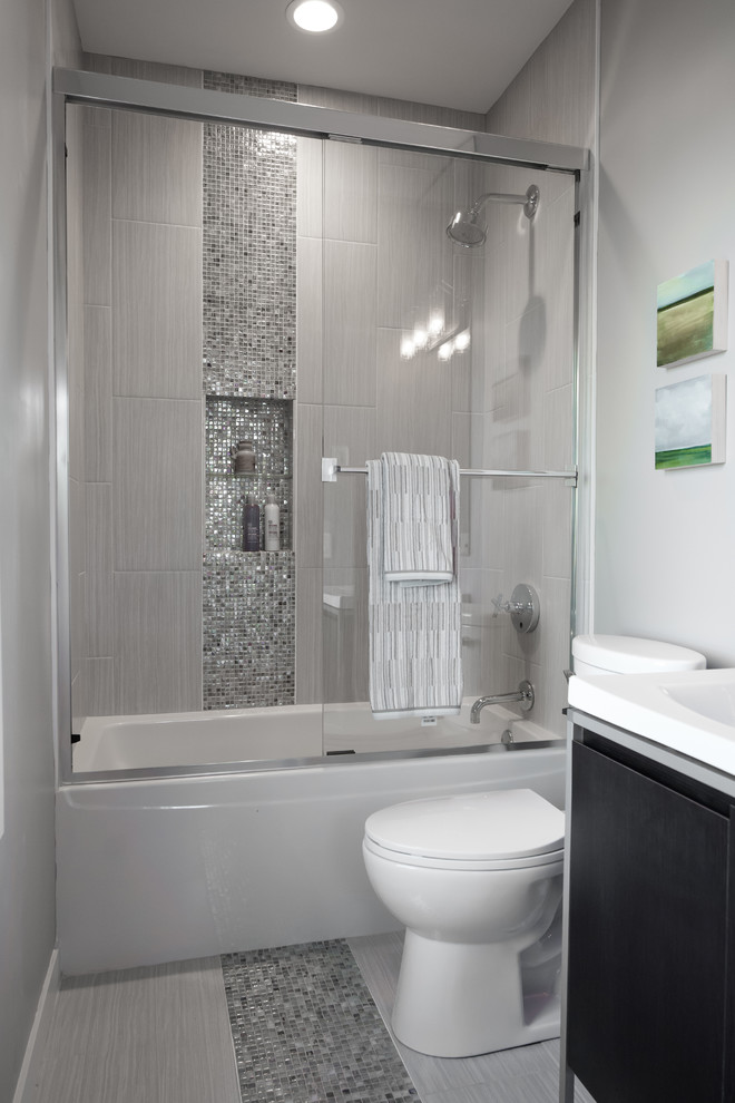 Photo of a small contemporary bathroom in Minneapolis with a console sink, flat-panel cabinets, dark wood cabinets, solid surface benchtops, an alcove tub, an alcove shower, gray tile, glass tile, grey walls and ceramic floors.