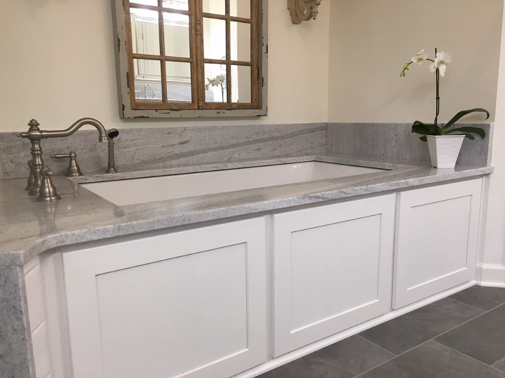 Inspiration for a mid-sized transitional master white tile and ceramic tile porcelain tile and gray floor corner shower remodel with recessed-panel cabinets, white cabinets, an undermount tub, a two-piece toilet, gray walls, an undermount sink, marble countertops and a hinged shower door