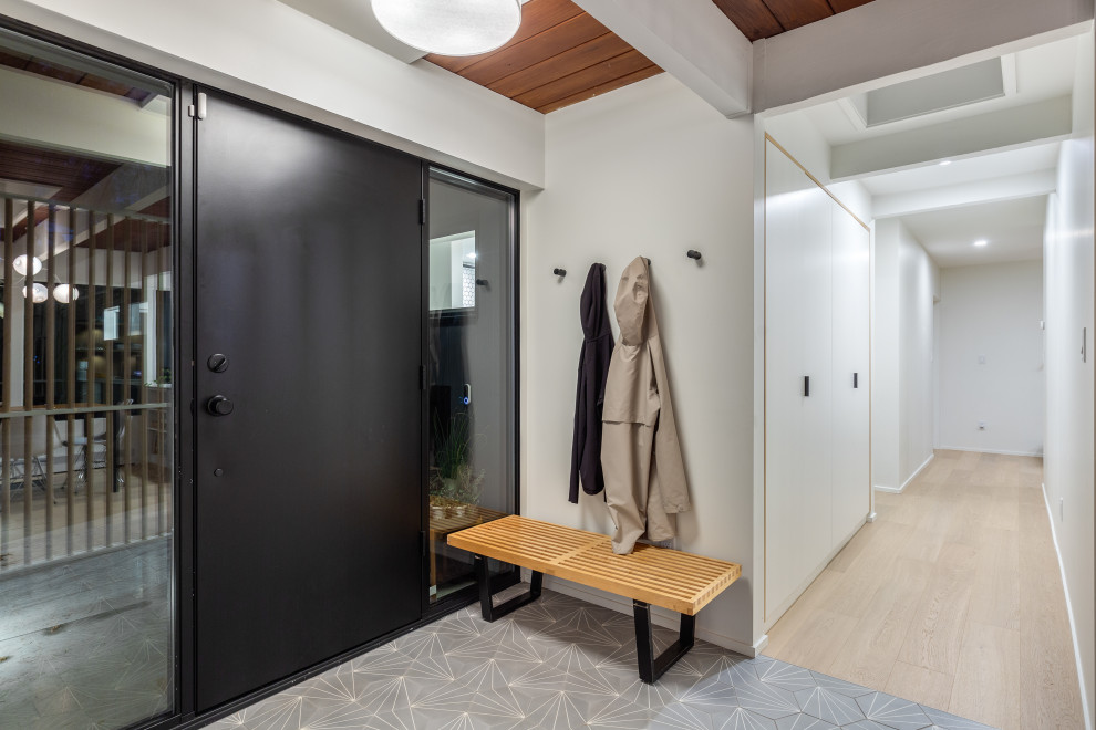 Mid-sized midcentury foyer in Vancouver with white walls, porcelain floors, a single front door, a black front door and grey floor.