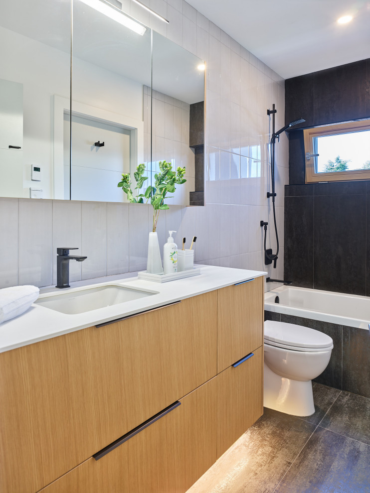 Inspiration for a mid-sized contemporary kids' white tile and ceramic tile porcelain tile, gray floor and single-sink bathroom remodel in Vancouver with flat-panel cabinets, light wood cabinets, a one-piece toilet, white walls, an undermount sink, quartz countertops, white countertops and a floating vanity