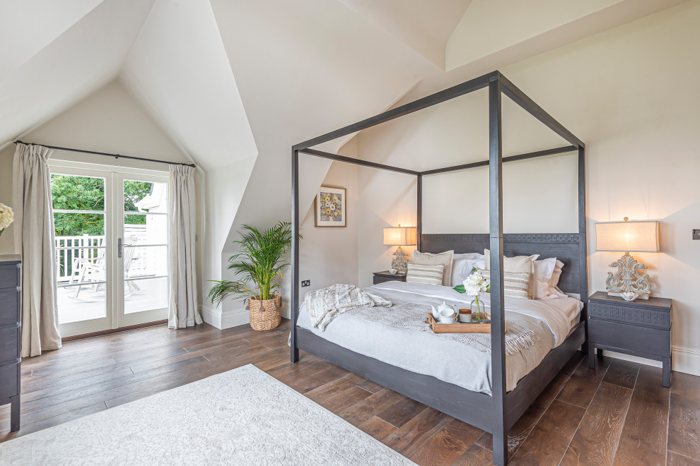 Inspiration for a transitional bedroom in Hampshire with white walls, dark hardwood floors, brown floor and vaulted.