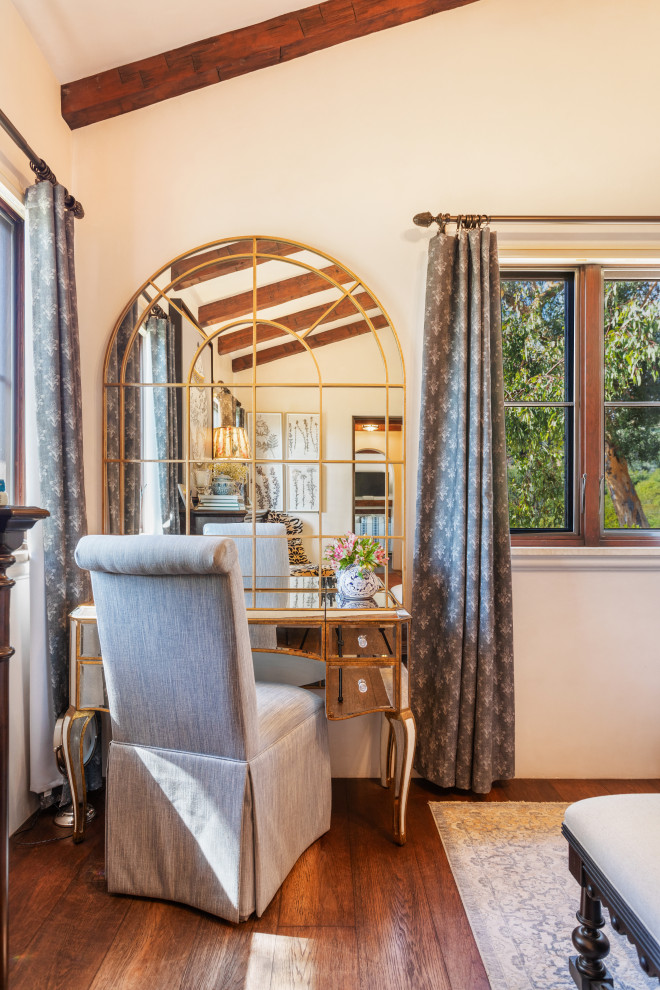 Kleines Mediterranes Hauptschlafzimmer mit weißer Wandfarbe, braunem Holzboden und freigelegten Dachbalken in Santa Barbara