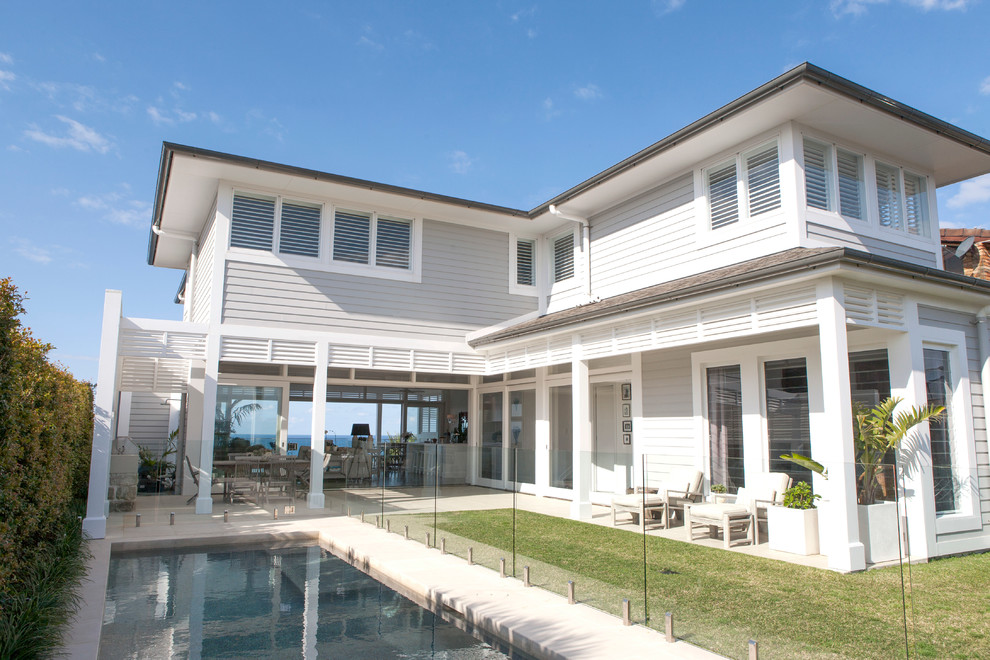 This is an example of a large beach style three-storey grey exterior in Sydney with mixed siding and a hip roof.