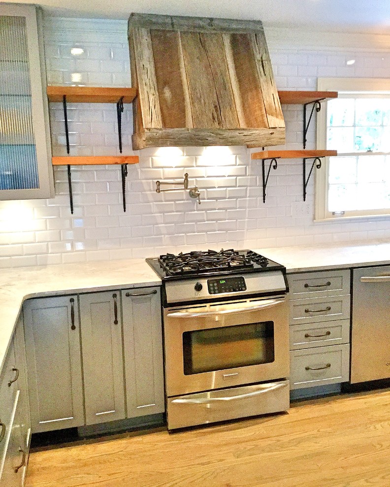 Mid-sized mountain style u-shaped light wood floor open concept kitchen photo in Atlanta with a farmhouse sink, shaker cabinets, gray cabinets, quartzite countertops, white backsplash, subway tile backsplash, stainless steel appliances and a peninsula
