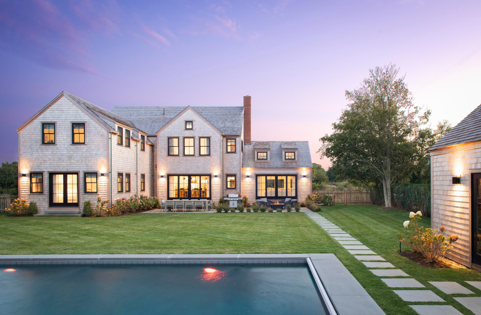 This is an example of a beach style two-storey grey house exterior in Boston with a gable roof and a shingle roof.