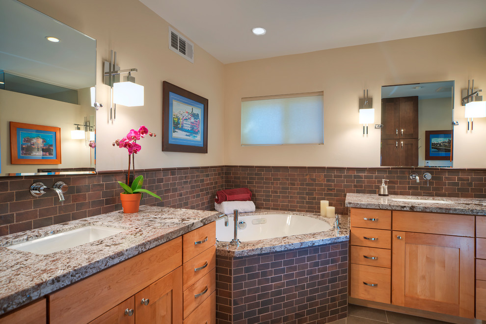 Large eclectic master bathroom in Phoenix with shaker cabinets, light wood cabinets, a corner tub, brown tile, beige walls, porcelain floors, an undermount sink, granite benchtops, subway tile, brown floor and grey benchtops.