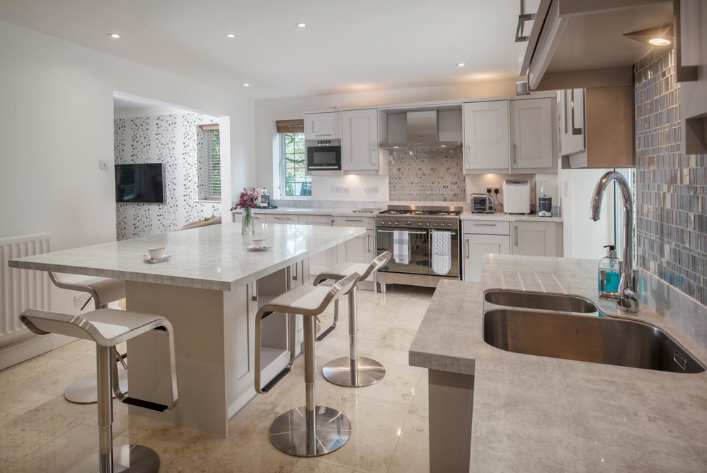 Enclosed kitchen - large transitional l-shaped limestone floor and beige floor enclosed kitchen idea in Ottawa with an undermount sink, shaker cabinets, white cabinets, quartz countertops, metallic backsplash, metal backsplash, stainless steel appliances and an island