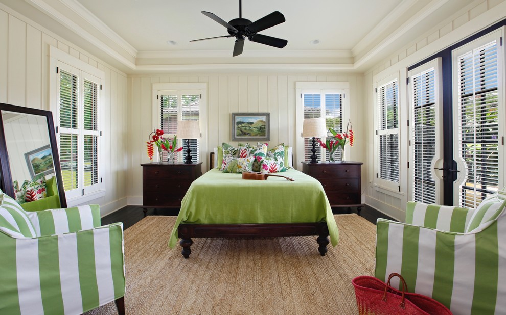 Inspiration for a tropical bedroom in Hawaii with white walls, dark hardwood floors and black floor.