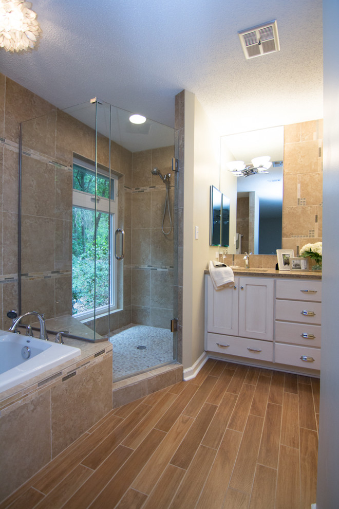 This is an example of a mid-sized transitional master bathroom in Atlanta with an undermount sink, shaker cabinets, white cabinets, a drop-in tub, a corner shower, beige tile and beige walls.