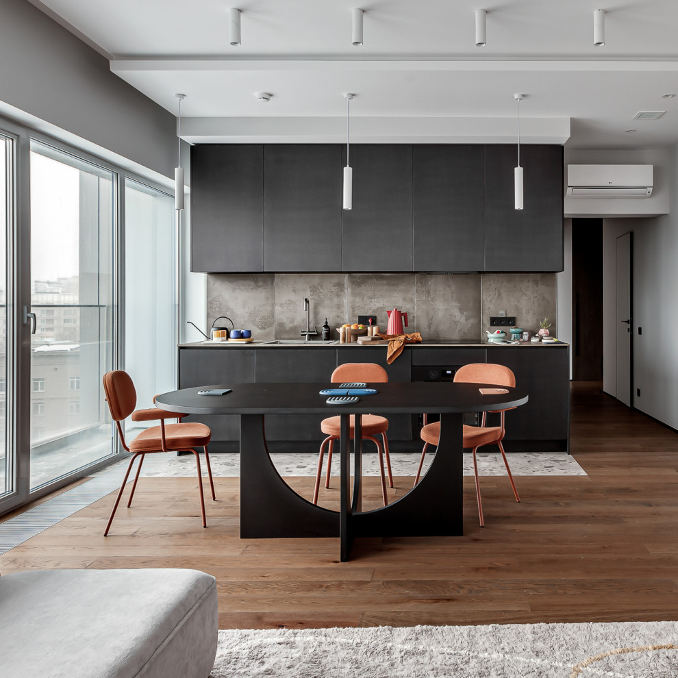 Expansive contemporary grey and white single-wall open plan kitchen in Moscow with a submerged sink, flat-panel cabinets, black cabinets, composite countertops, beige splashback, porcelain splashback, medium hardwood flooring, no island, brown floors and beige worktops.