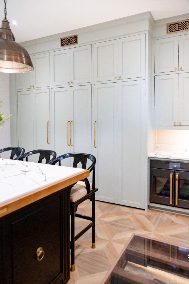 Large transitional u-shaped porcelain tile and brown floor kitchen photo in Charleston with an undermount sink, shaker cabinets, green cabinets, marble countertops, beige backsplash, an island and beige countertops