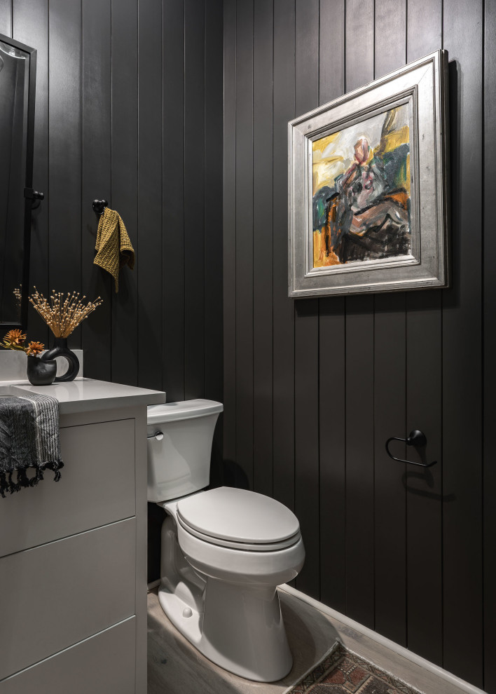 Idée de décoration pour un petit WC et toilettes tradition avec un placard à porte plane, des portes de placard blanches, un mur noir, parquet clair, un lavabo encastré, un plan de toilette en quartz modifié, un sol marron, meuble-lavabo encastré, du lambris et un plan de toilette gris.