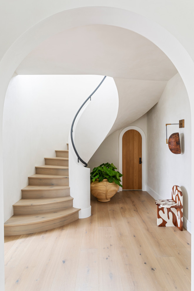 Inspiration for an expansive beach style wood curved staircase in Charleston with wood risers and metal railing.