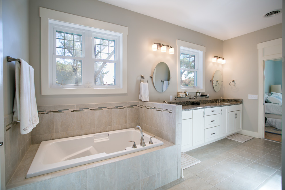 Inspiration for a large transitional master beige tile, gray tile and ceramic tile porcelain tile and gray floor drop-in bathtub remodel with shaker cabinets, white cabinets, a two-piece toilet, gray walls, an undermount sink and granite countertops