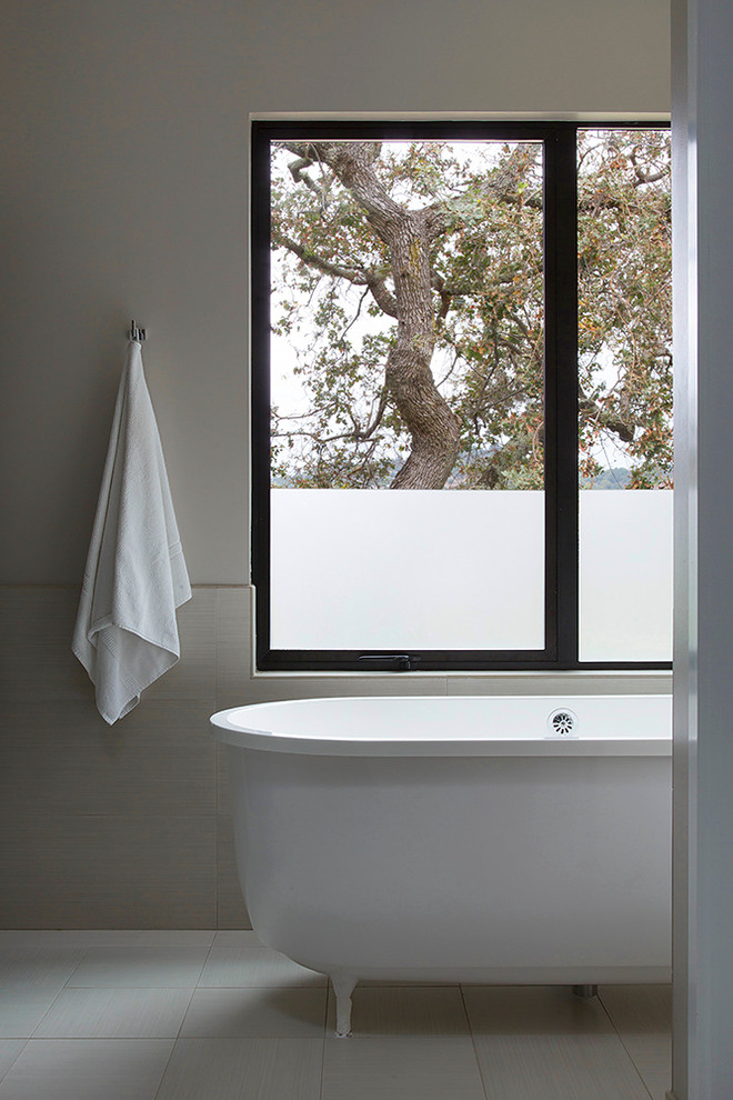 Photo of a mid-sized modern master bathroom in San Francisco with a freestanding tub, beige tile, porcelain tile, beige walls and porcelain floors.