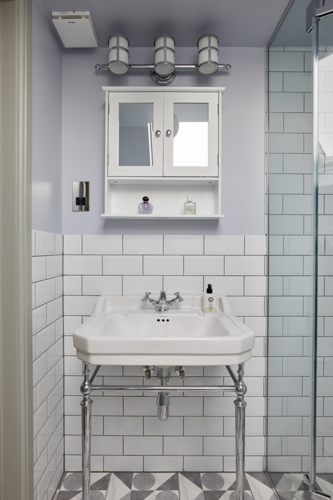 Идея дизайна: маленькая серо-белая ванная комната в стиле неоклассика (современная классика) с открытым душем, белой плиткой, белыми стенами, полом из керамогранита, душевой кабиной, раковиной с пьедесталом, серым полом, душем с распашными дверями и тумбой под одну раковину для на участке и в саду
