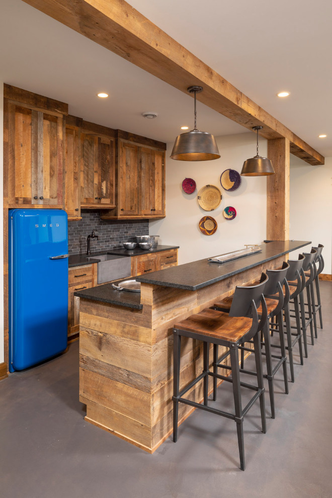 Inspiration for a mid-sized country wet bar in Minneapolis with an integrated sink, flat-panel cabinets, distressed cabinets, granite benchtops, multi-coloured splashback, ceramic splashback, concrete floors, grey floor and black benchtop.