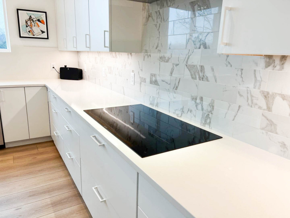 Eat-in kitchen - mid-sized modern u-shaped vinyl floor and multicolored floor eat-in kitchen idea in Other with an undermount sink, flat-panel cabinets, white cabinets, quartz countertops, metallic backsplash, quartz backsplash, stainless steel appliances, an island and white countertops