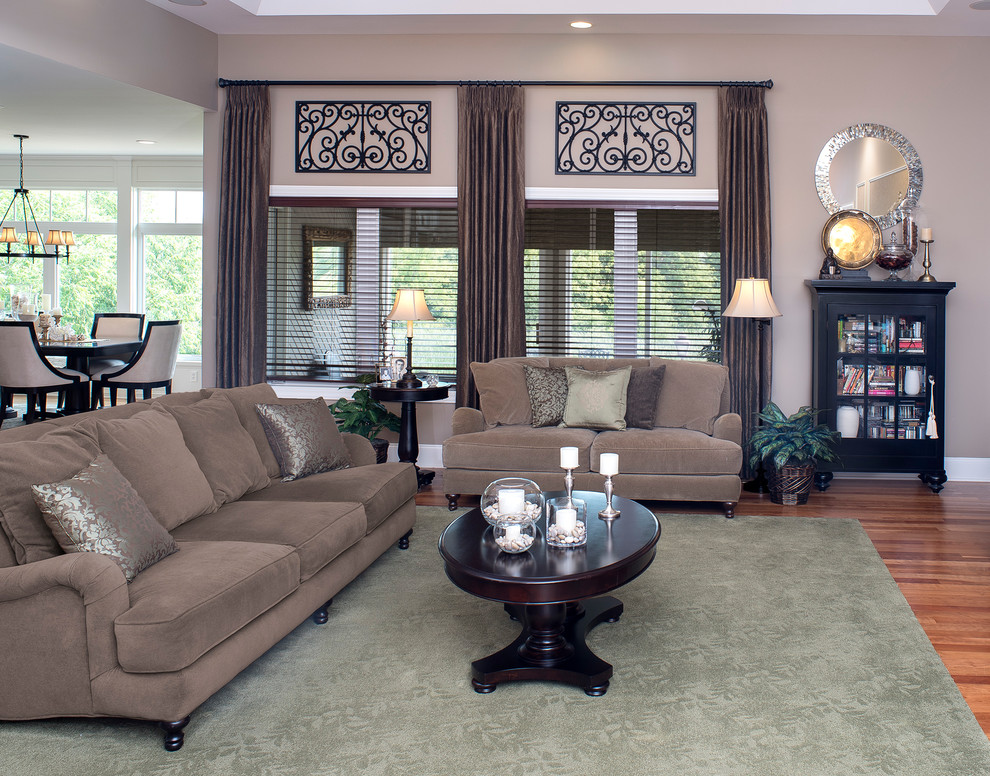 Mid-sized traditional formal open concept living room in Milwaukee with beige walls, medium hardwood floors, no fireplace, a wall-mounted tv and brown floor.