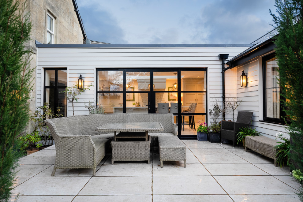 Réalisation d'une façade de maison grise design en bois de taille moyenne et de plain-pied avec un toit plat et un toit bleu.