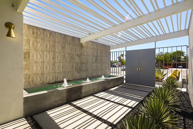 Photo of a mid-sized midcentury front yard patio in Los Angeles with concrete slab and a pergola.