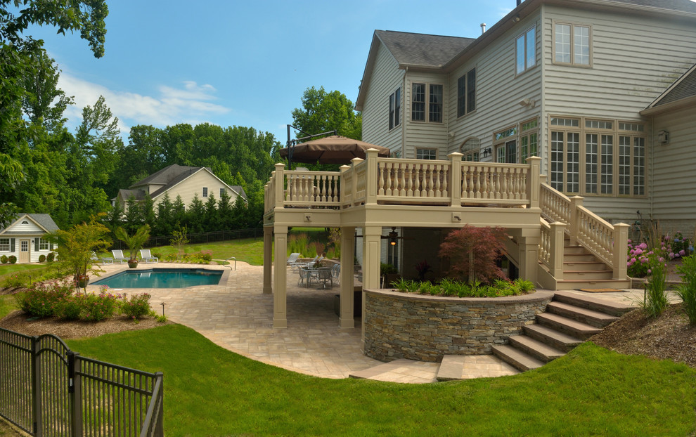 Inspiration for a large traditional backyard patio in Baltimore with a water feature, brick pavers and a roof extension.