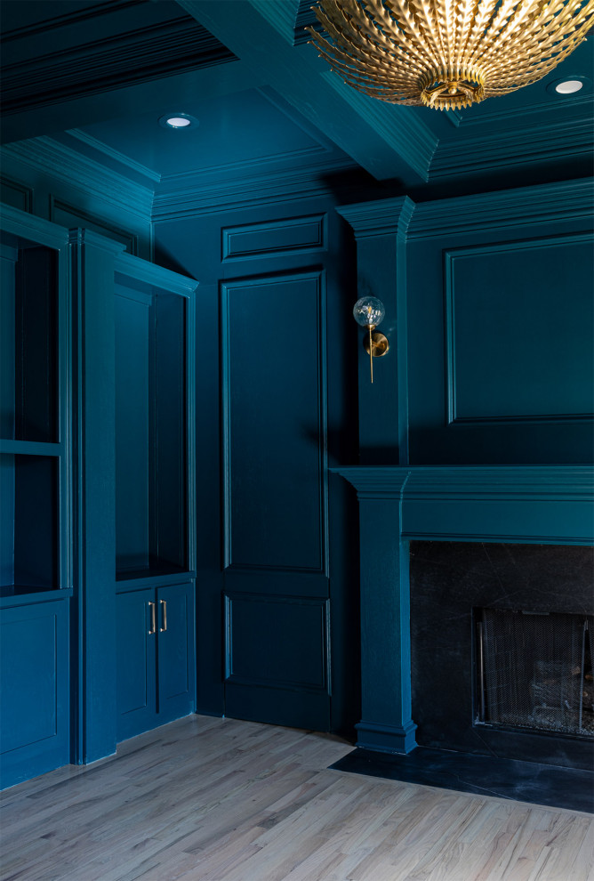 Großes Klassisches Lesezimmer mit blauer Wandfarbe, hellem Holzboden, Kamin, Kaminumrandung aus Stein, freistehendem Schreibtisch, braunem Boden, Kassettendecke und vertäfelten Wänden in Dallas