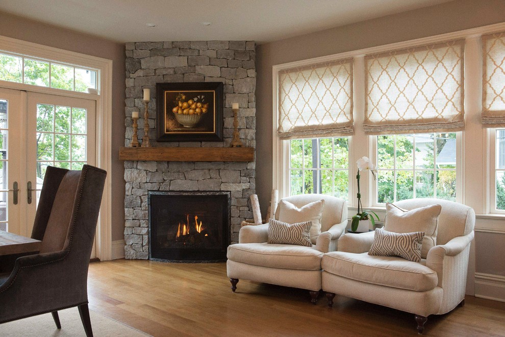Photo of a large transitional open concept family room in New York with a corner fireplace, a stone fireplace surround, grey walls and medium hardwood floors.