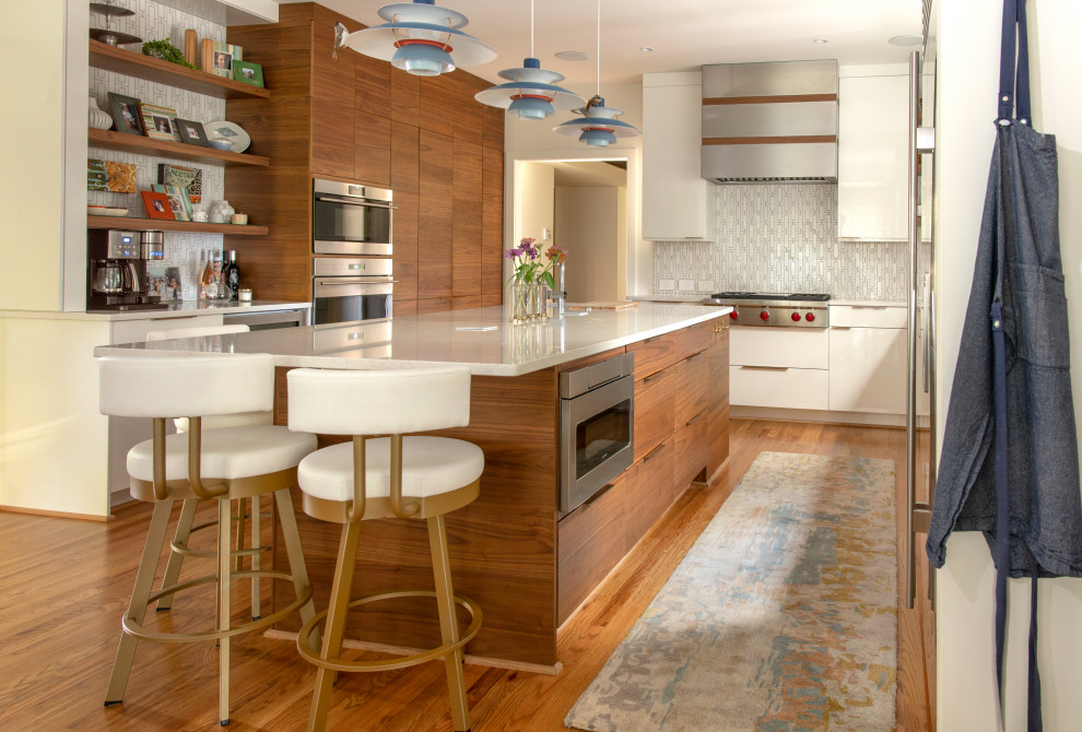 Foto på ett 50 tals vit kök, med en undermonterad diskho, släta luckor, skåp i mellenmörkt trä, flerfärgad stänkskydd, stänkskydd i mosaik, rostfria vitvaror, mellanmörkt trägolv, en köksö och brunt golv