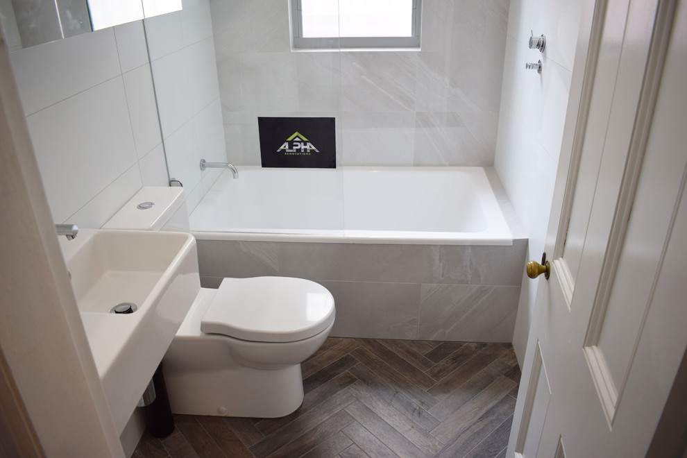 Design ideas for a small modern master bathroom in Sydney with flat-panel cabinets, white cabinets, a drop-in tub, a shower/bathtub combo, a two-piece toilet, white tile, ceramic tile, white walls, porcelain floors, a wall-mount sink, brown floor and an open shower.