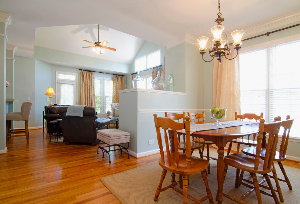 This is an example of a small traditional open plan dining in Charlotte with blue walls and medium hardwood floors.