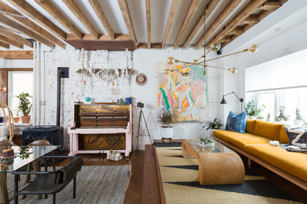 Eclectic family room in New York with white walls, medium hardwood floors and brown floor.