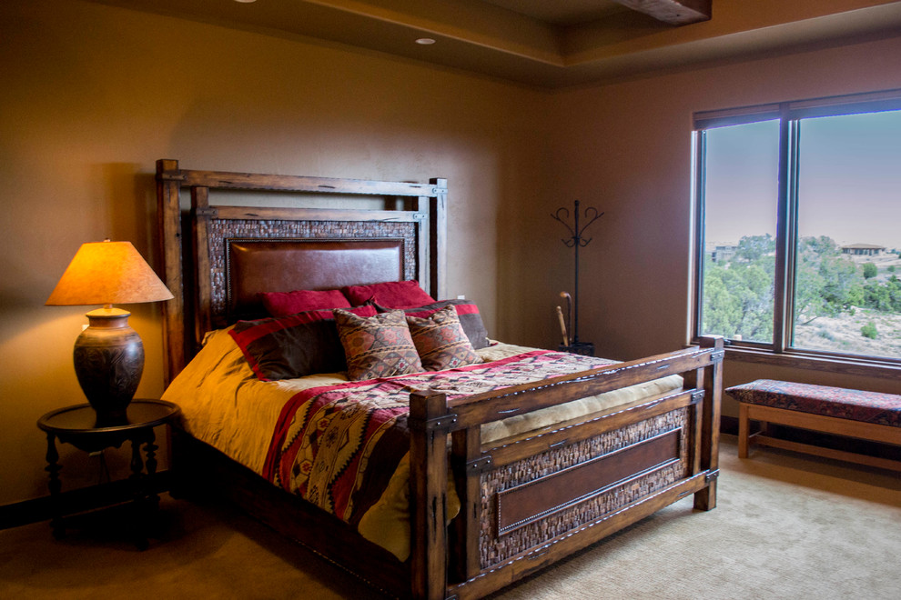 Inspiration for a large country master bedroom in Denver with beige walls, carpet, beige floor and exposed beam.