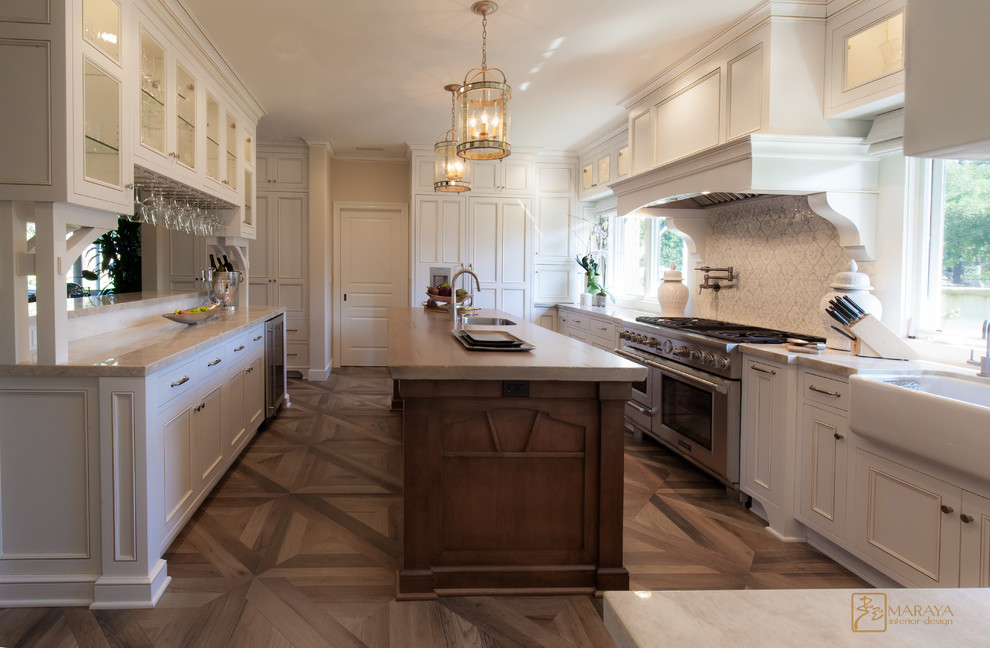 This is an example of a large country u-shaped open plan kitchen in Los Angeles with a farmhouse sink, recessed-panel cabinets, white cabinets, granite benchtops, white splashback, mosaic tile splashback, panelled appliances, porcelain floors and multiple islands.