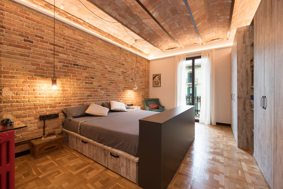 This is an example of a large industrial master bedroom in Other with white walls, porcelain floors, no fireplace, white floor, vaulted and brick walls.