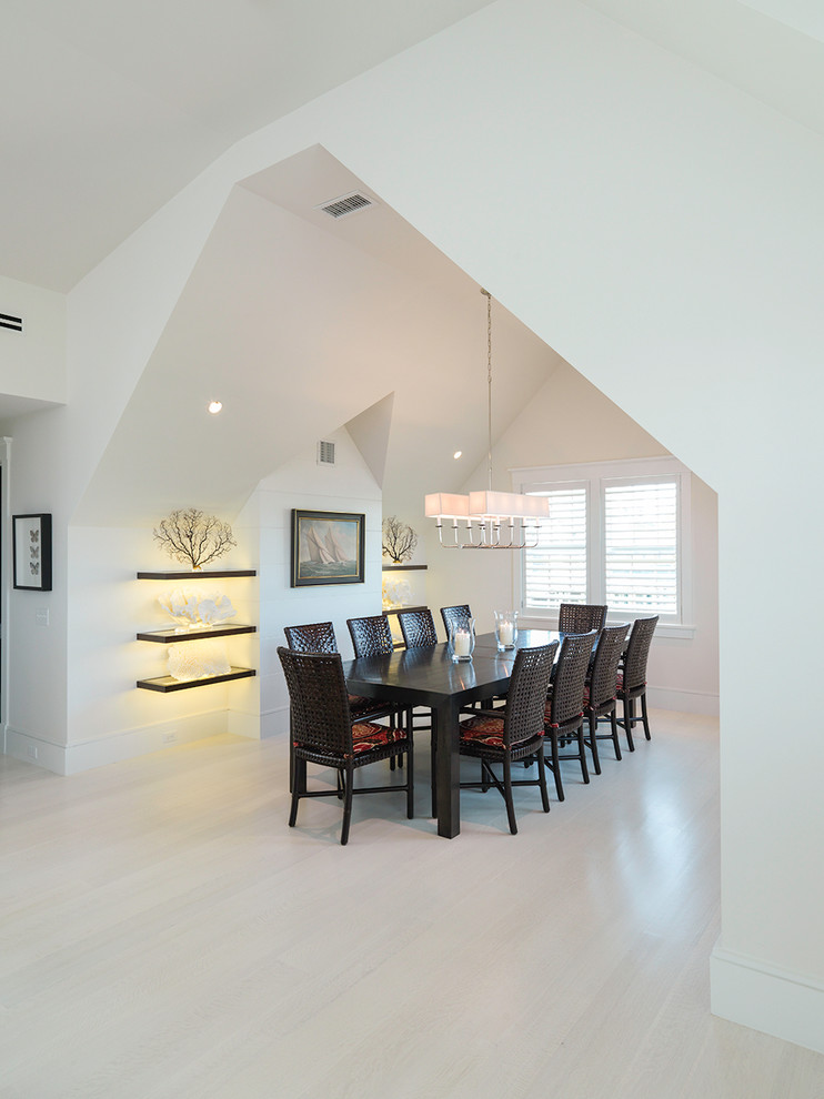 Photo of a large beach style separate dining room in Boston with white walls, light hardwood floors, no fireplace and white floor.