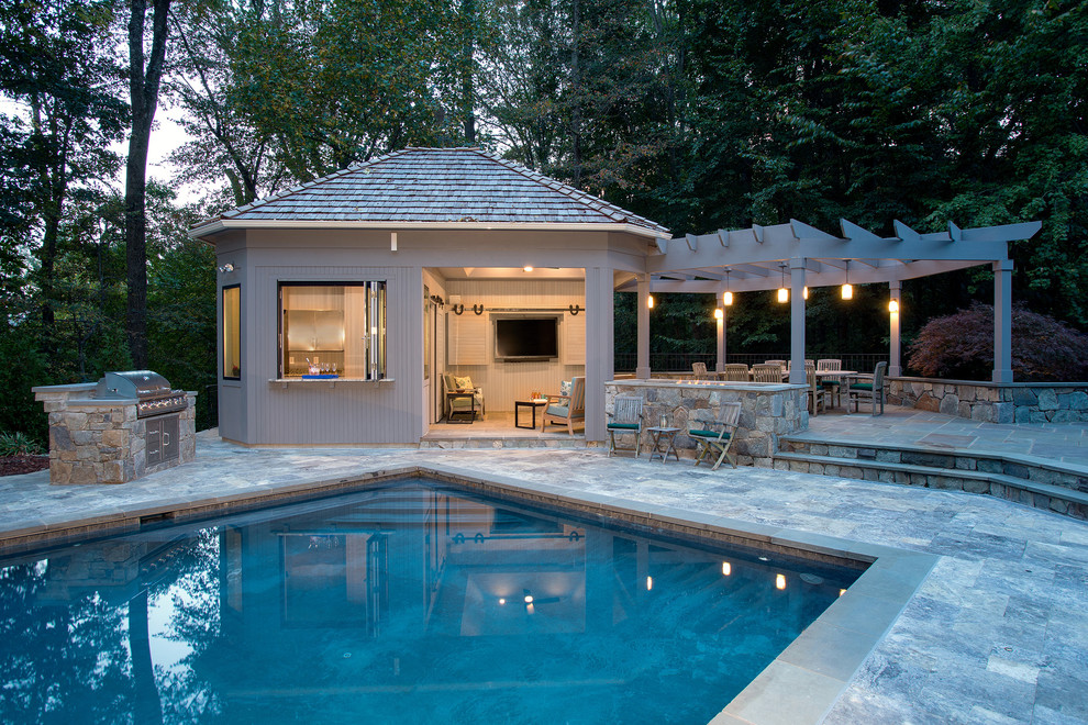 Photo of an expansive traditional backyard rectangular pool in DC Metro with natural stone pavers and a pool house.