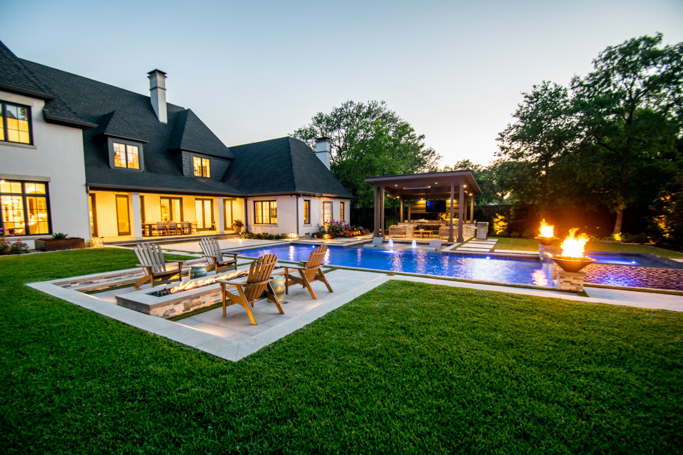 Example of a large transitional backyard tile and custom-shaped lap pool design in Dallas