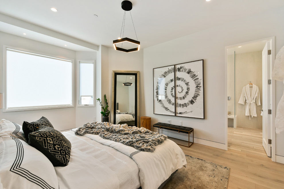 Photo of a contemporary master bedroom in San Francisco with white walls, light hardwood floors and beige floor.