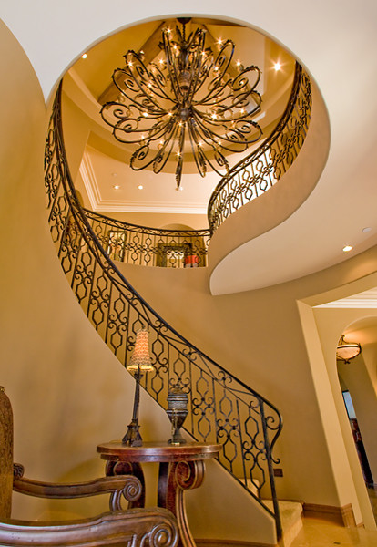 Photo of a large mediterranean carpeted spiral staircase in Orange County with carpet risers.
