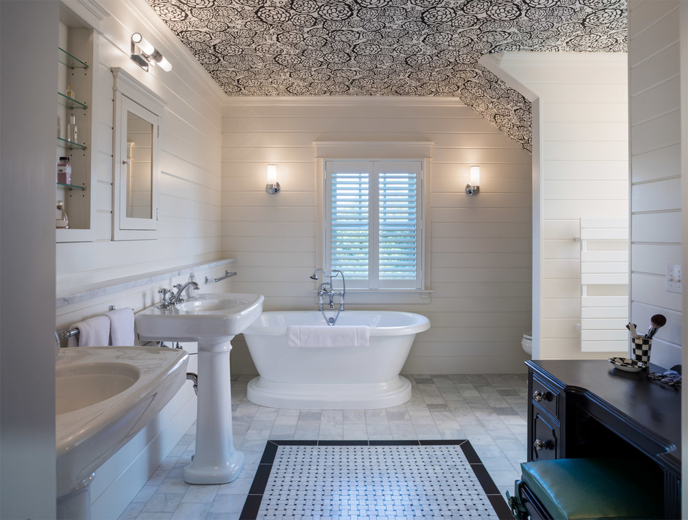 This is an example of a country bathroom in Providence with a freestanding tub, white walls, marble floors and a pedestal sink.