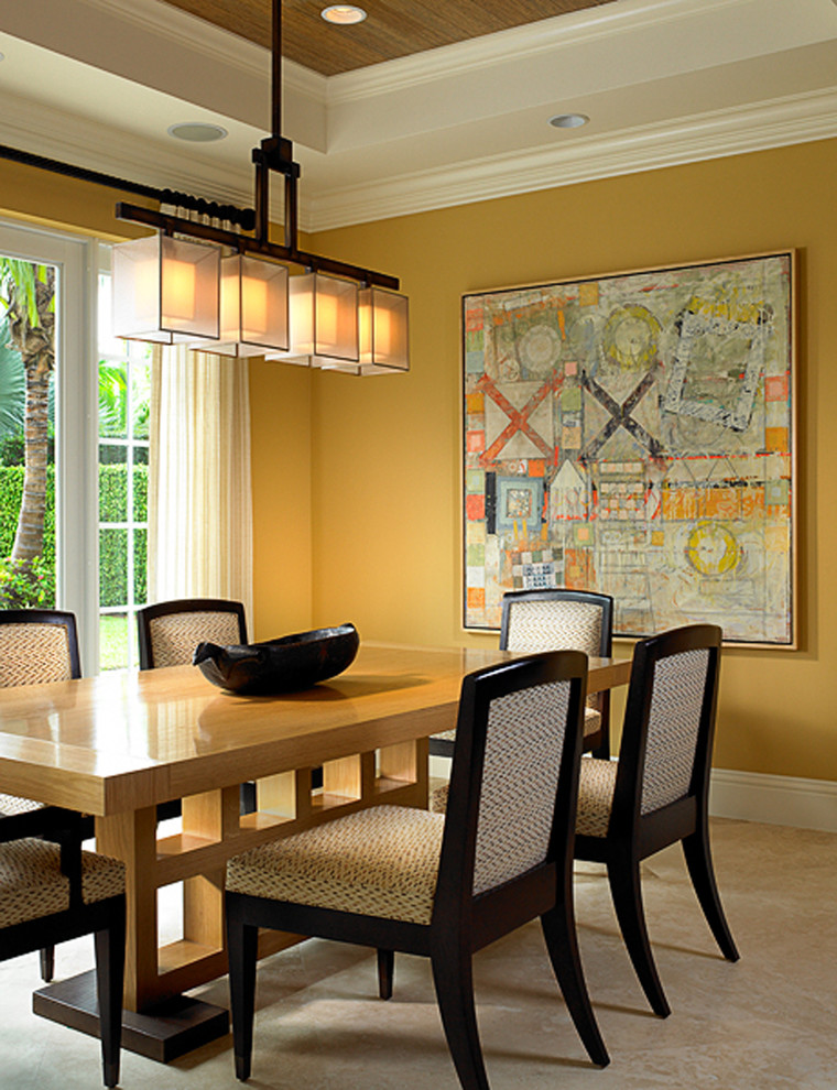 Inspiration for a large asian dining room in Miami with yellow walls, limestone floors and no fireplace.