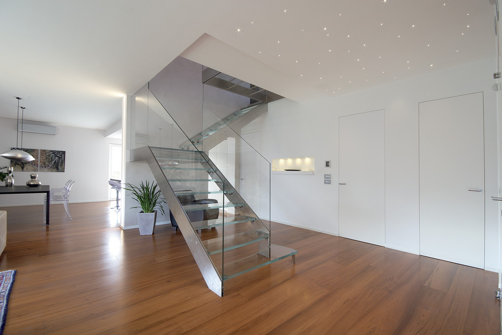 Photo of a mid-sized contemporary glass l-shaped staircase in Florence with open risers.