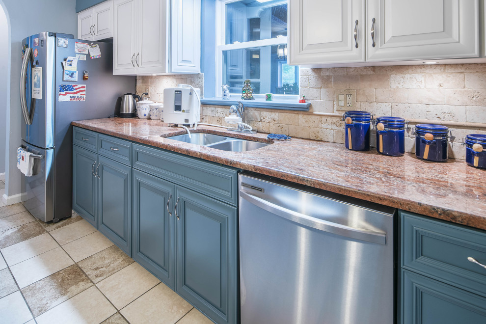 Mid-sized transitional l-shaped separate kitchen in Baltimore with an undermount sink, recessed-panel cabinets, blue cabinets, granite benchtops, beige splashback, stone tile splashback, stainless steel appliances, ceramic floors, with island, beige floor and orange benchtop.